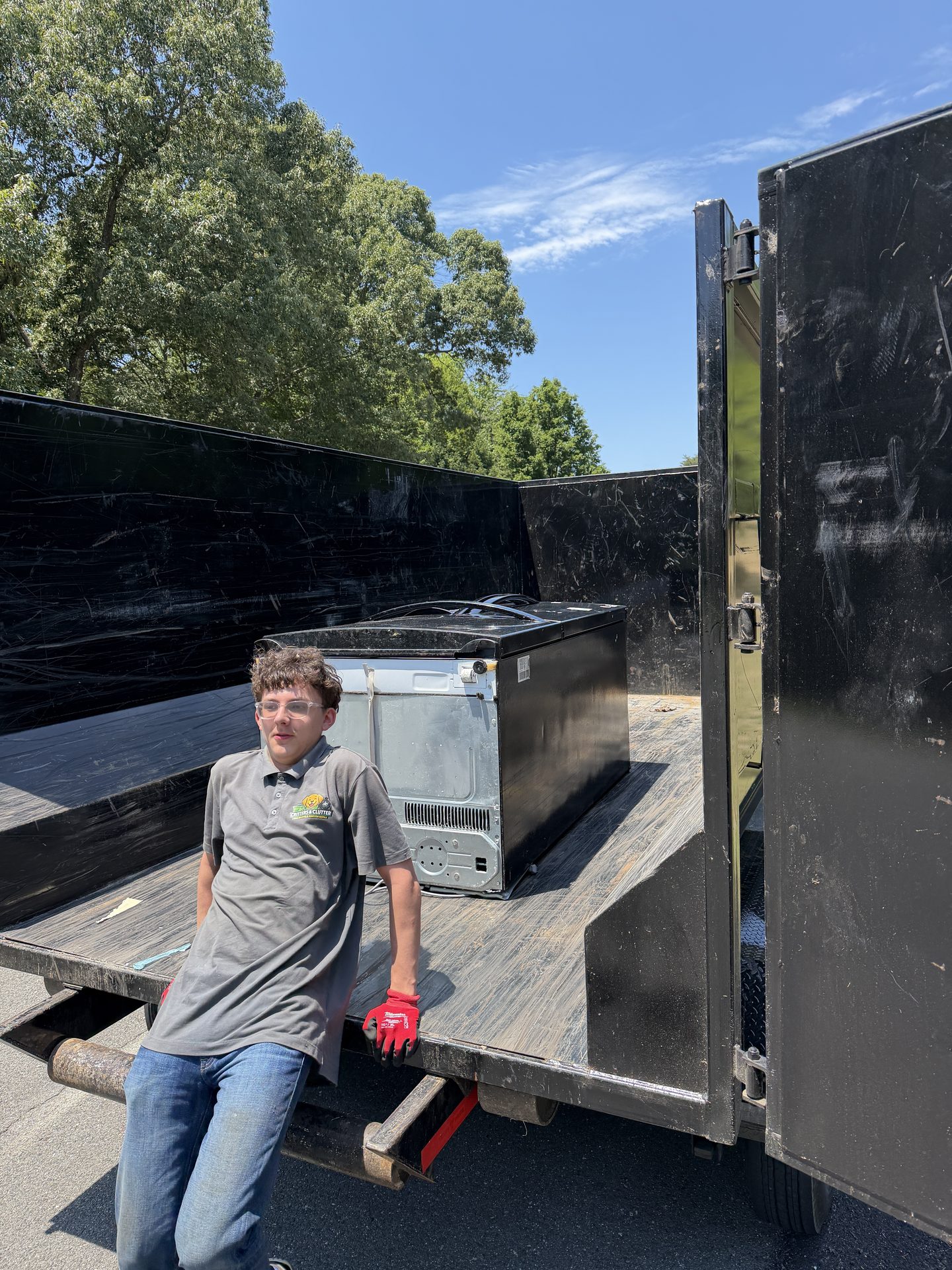 Critters & Clutter crew member with an oven loaded in the dump trailer during an appliance removal