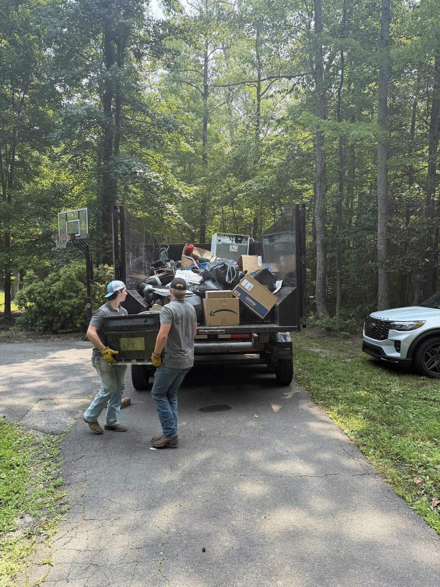 Critters & Clutter team carrying items during a residential junk removal job